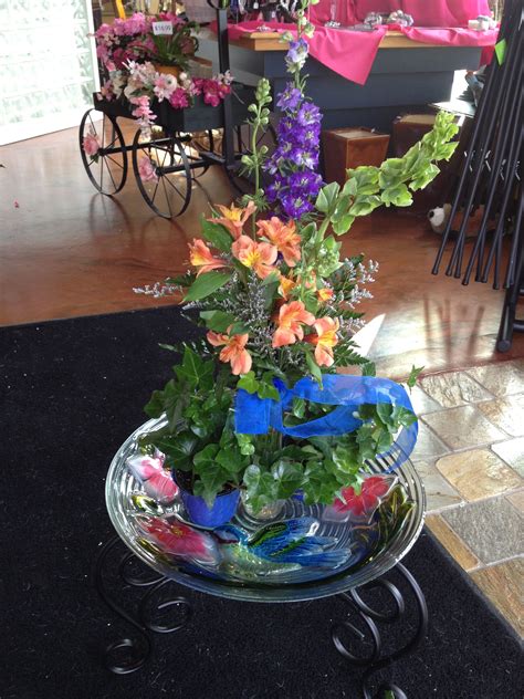 A Beautiful Glass Birdbath With A Fresh Floral Arrangement Is The