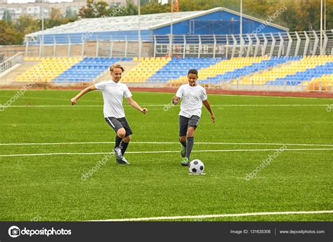 Chicos Jugando Al Fútbol En El Estadio Fotografía De Stock