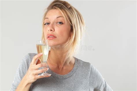 Chic Young Blond Woman Enjoying Drinking Flute Of Bubbly Wine Stock