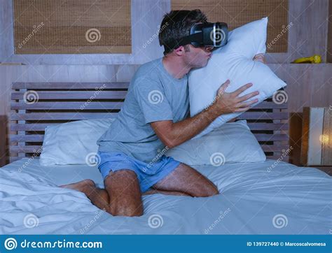 Young Excited And Aroused Man At Home Wearing 3d Virtual Realty Goggles Having Fun On Bed