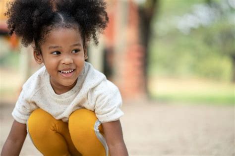 Happy African American Little Girl Smiling At Playground In The Park In