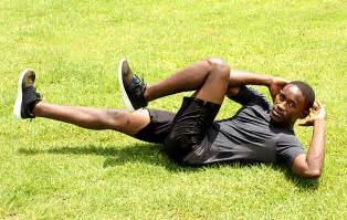 Fit Man Doing Ab Bicycle Crunches On Grass