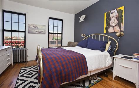 A Navy Blue Accent Wall Is The Focal Point Of This Bedroom