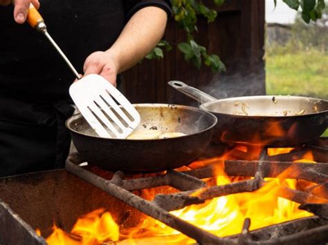 Cooking On The Grill In A Frying Pan Frying Pan On Fire A Man Stirs