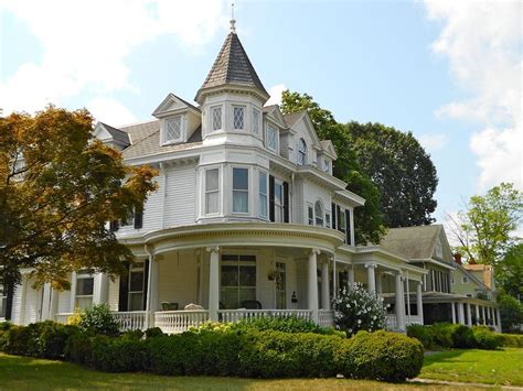 A Large White Victorian Style House In The Country