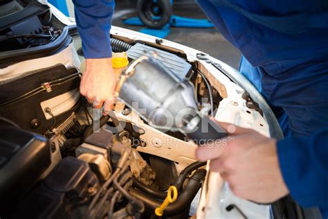 Mechanic Examining Under Hood Of Car With Torch Stock Photos