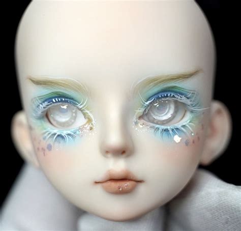 A Close Up Of A Dolls Face With Blue Eyes