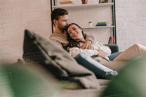 Attractive Young Couple Cuddling On Couch At Home Stock Photo Dissolve