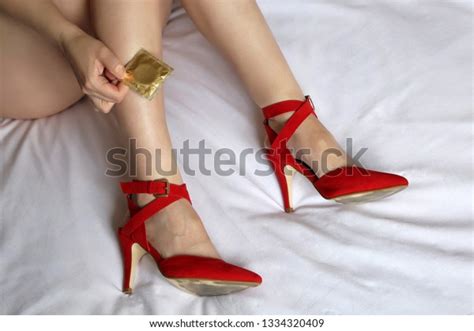 Naked Girl With Condom On The Bed Safe Sex Concept Woman With Sexy Legs In Red Shoes On High