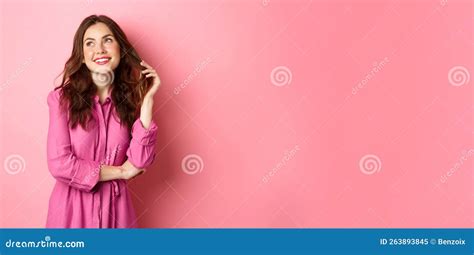 Beautiful Coquettish Woman In Trendy Dress And Make Up Looking Thoughtful Aside Gazing Up With