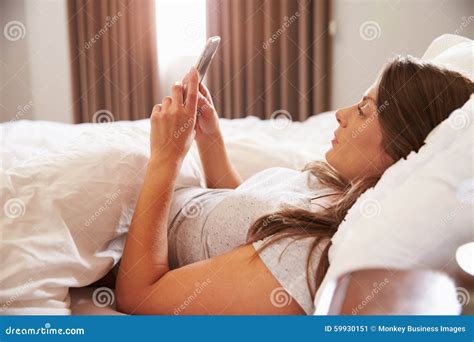 Woman Lying In Bed Whilst Mobile Phone Stock Image Image Of Woman