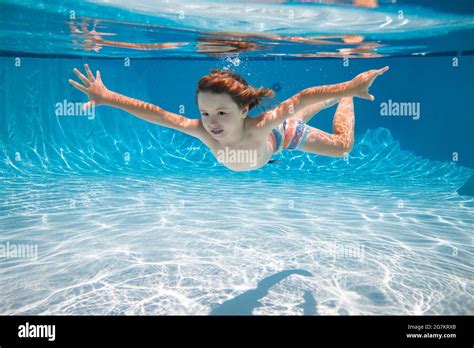 Child Swim Underwater In Pool Kid Boy Swimming And Diving Underwater