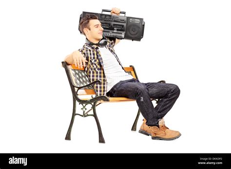 Guy Holding A Boombox On His Shoulder And Sitting On A Wooden Bench