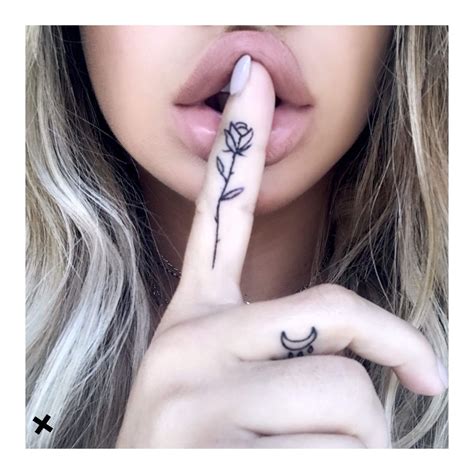 A Woman With A Rose Tattoo On Her Finger Making A Hush Gesture To The