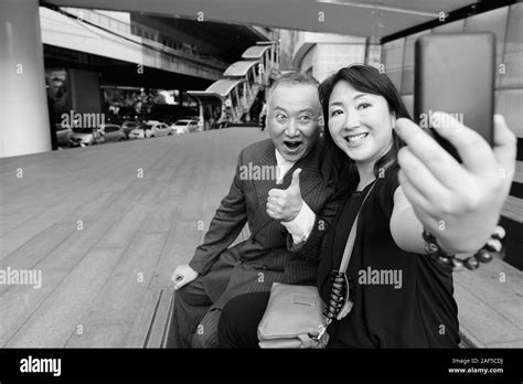Mature Asian Businessman And Mature Asian Woman Exploring The City