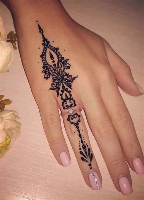 A Womans Hand With A Black And White Henna Tattoo Design On It