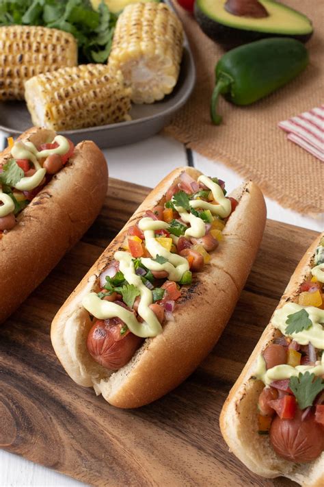 Hot dogs inside a olive garden breadsticks with cheese, and beans. Mexican Style Hot Dogs