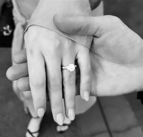 Two People Holding Each Others Hand With Their Wedding Ring On Top Of Them