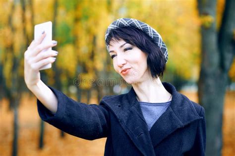 Beautiful Woman Taking Selfie By Smartphone And Having Fun In Autumn City Park Fall Season