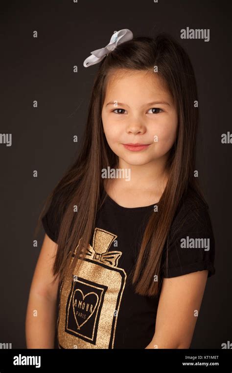Portrait Of A 7 Year Old Girl With Dark Hair In A Studio Against A