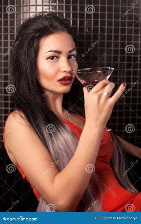 Alluring Girl With The Glass In Her Hand Sitting In A Bar And Posing