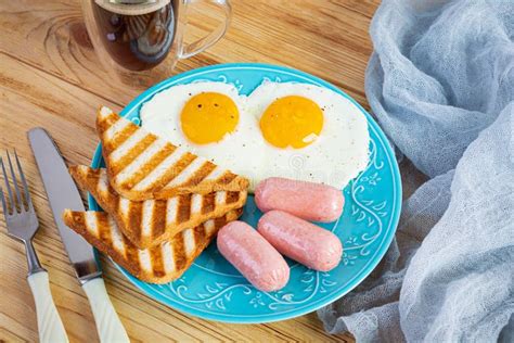Tasty Breakfast With Eggs Sausages Toasts And Cup Of Coffee American