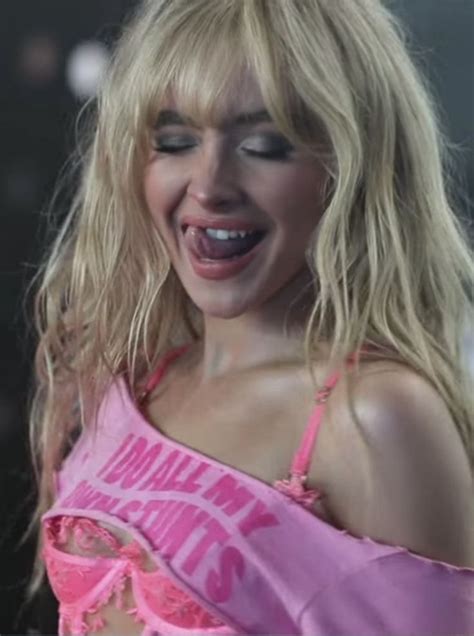 A Woman With Blonde Hair Wearing A Pink Top