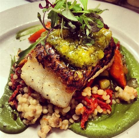 Seared Chilean Sea Bass Served On Top Of Sun Dried Tomato Cous Cous And Honey Glazed Carrots