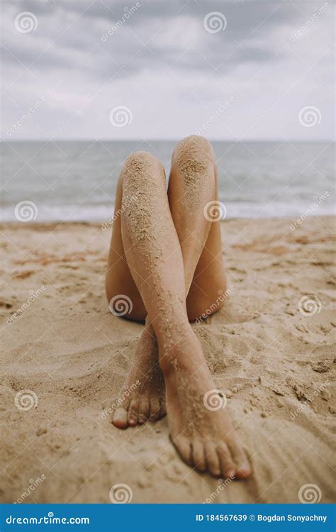 Summer Vacation Tanned Legs Of A Girl On Beach With Sand On Smooth