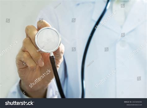 Halfstanding Doctor Without Face Holding Stethoscope Stock Photo