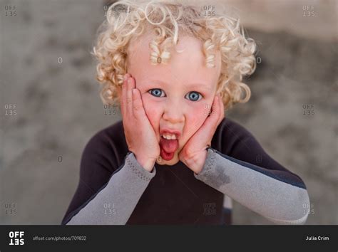 Portrait Of Boy With Blonde Curly Hair Making Silly Face Stock Photo