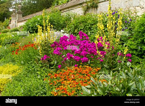 Cottage Garden With Herbaceous Border Of Summer Flowering Perennials At