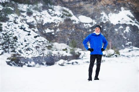 Senior Man Standing Outside In Snow Landscape Stock Image