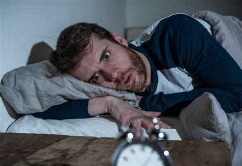 Desperate Stressed Young Man Whit Insomnia Lying In Bed Staring At