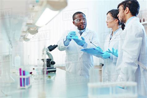 Three scientists working together in a laboratory - Stock Photo - Dissolve