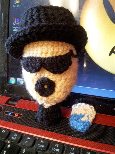A Crocheted Stuffed Animal Wearing Sunglasses And A Hat On Top Of A Laptop
