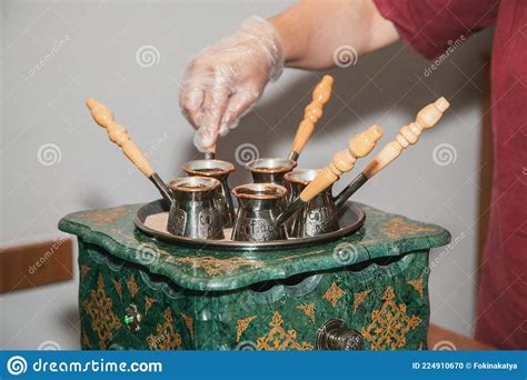Woman Makes Turkish Coffee On A Coffee Machine With Sand In Cezve