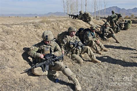 Soldiers Take Cover Behind A Berm Photograph By Stocktrek Images