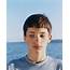 Portrait Of Serious Adolescent Boy Looking Away From Camera Ocean In 