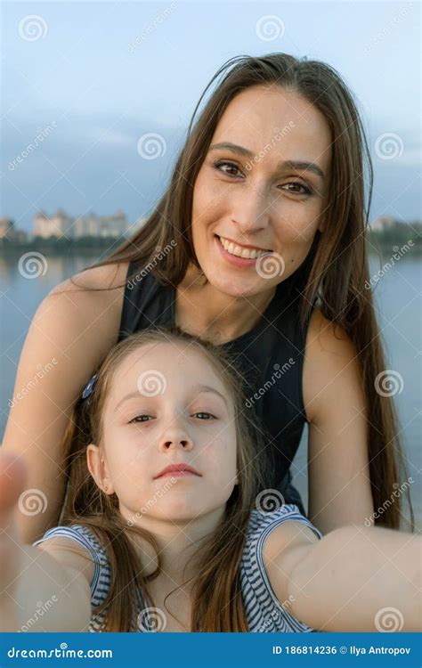 Mom And Daughter Take Selfies And Look Directly At The Camera They Are Smile Beautifully And