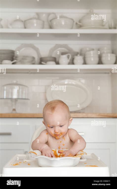 Messy Baby Eating In High Chair Stock Photo Alamy