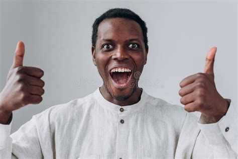 Emotional African American Guy Shows Thumbs Up On Light Grey Stock