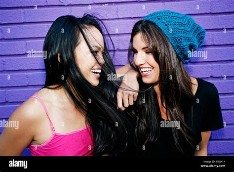 Women Laughing Near Purple Brick Wall Stock Photo Alamy