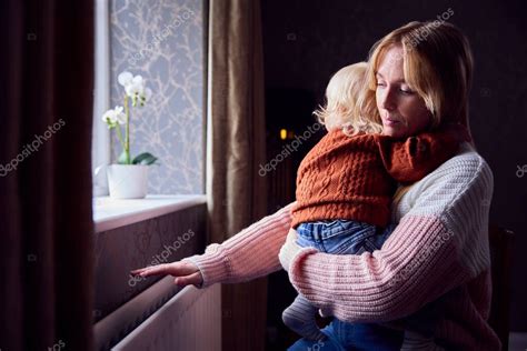 Madre Con Hijo Tratando De Mantener Caliente Por Radiador En Casa