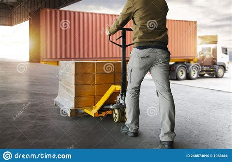 Workers Unloading Packaging Boxes On Pallets To The Cargo Container Trucks Loading Dock