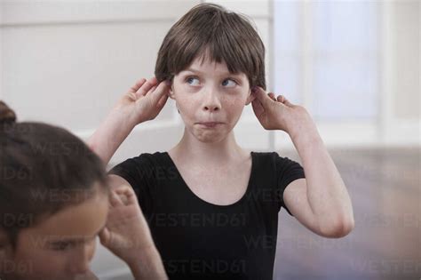 Girl With Holding Ears Pulling A Face In Ballet School Stock Photo