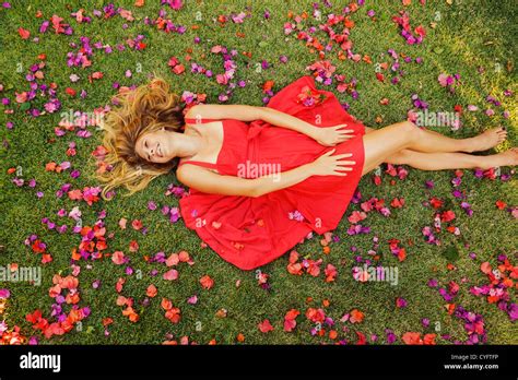 Beautiful Young Woman Lying On Grass With Flowers Stock Photo Alamy