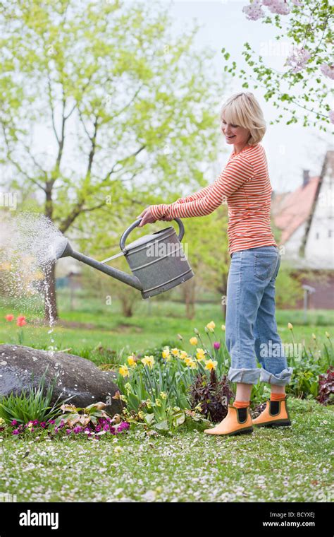 Woman Watering Garden Flowers Stock Photo Alamy