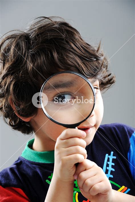 Portrait Of Child Looking Closely With Magnifying Glass Royalty Free
