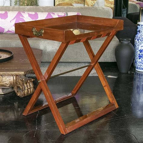Place the stand next to the table and bring out the food on the tray. Butler tray table by Ralph Lauren has a chestnut finish on ...
